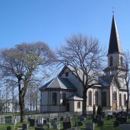 Fet kirke med prestegården i bakgrunnen